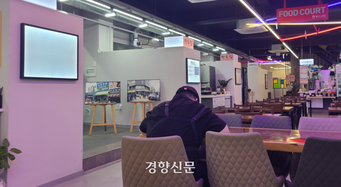 전북 익산 중앙시장 청년몰인 ‘상상노리터’에 손님이 없자 한 점포 점주가 식당 의자에 앉아 쉬고 있다. 김창효 선임기자