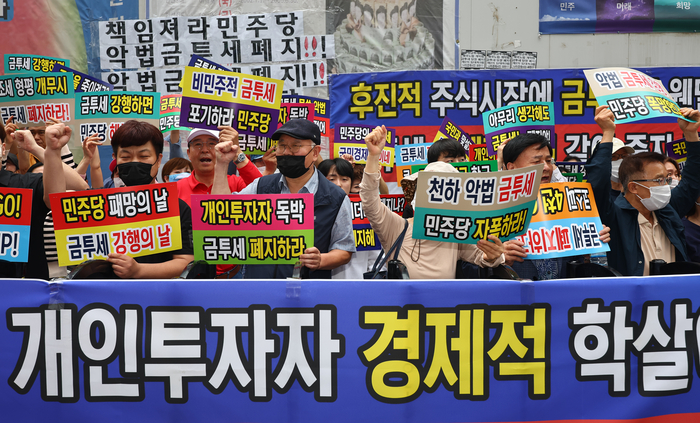 한국주식투자자연합회(한투연) 회원들이 지난 5월30일 서울 영등포구 더불어민주당 당사 앞에서 금융투자소득세(금투세) 폐지 촉구 집회를 열고 있다. 연합뉴스